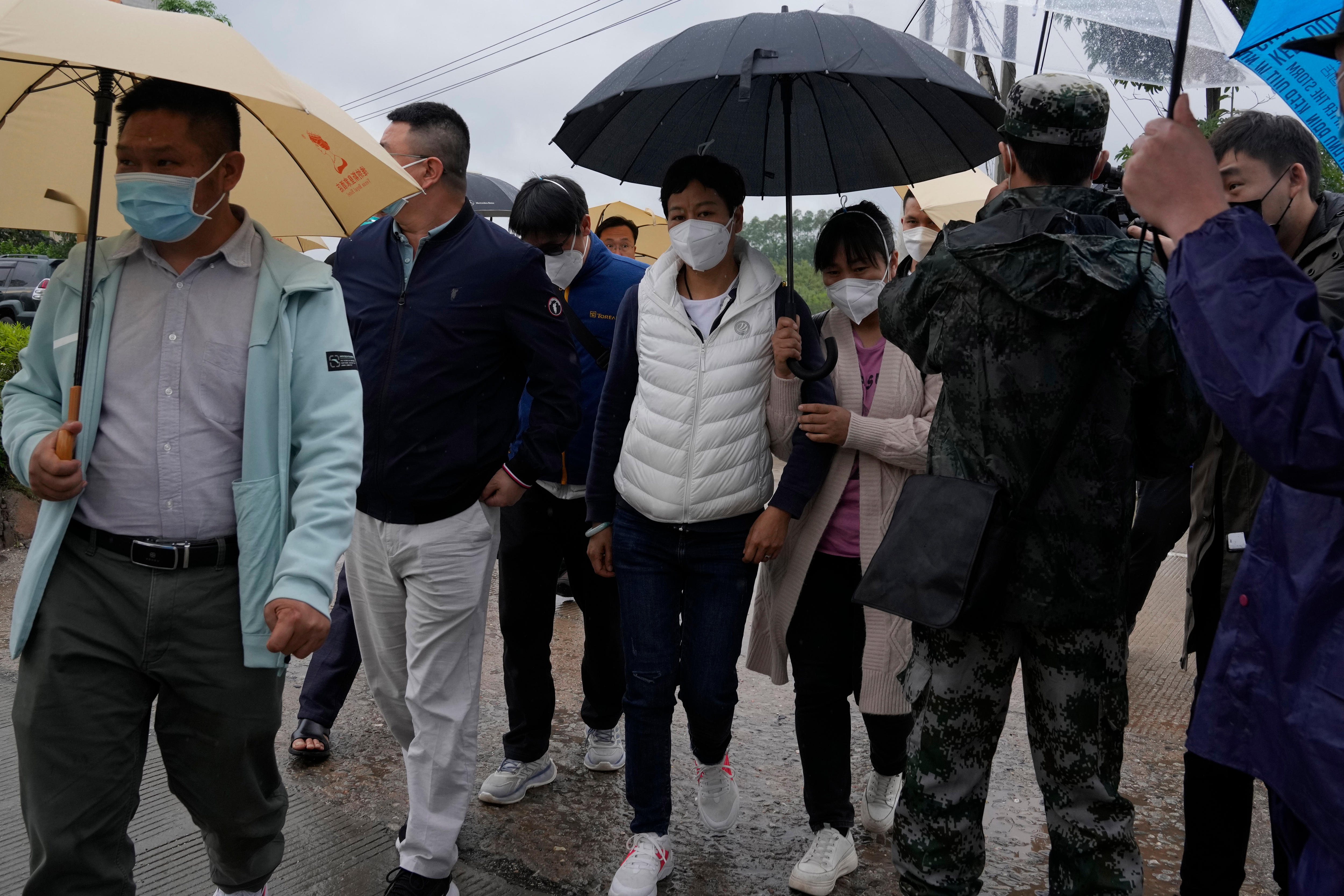 People walk under umbrellas.